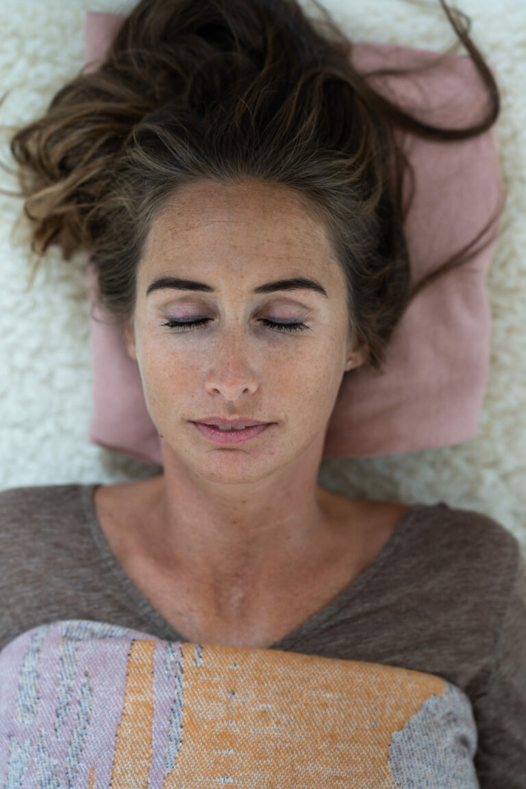 Marisa ligt ontspannen met gesloten ogen tijdens Yoga Nidra